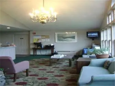 a lobby with a couch and chairs and a chandelier at Knights Inn Hadley in Hadley