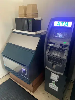 an atm machine in an office next to a printer at Domino Inn in North Bergen