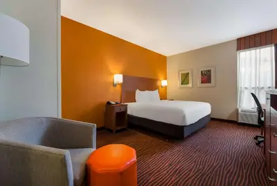 a hotel room with a bed and a chair at Best Western Executive Hotel New Haven-West Haven in West Haven