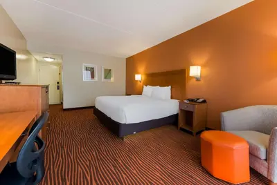 a hotel room with a bed and a chair at Best Western Executive Hotel New Haven-West Haven in West Haven
