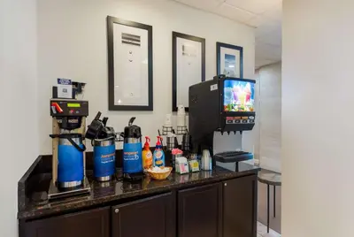 a counter top with a coffee maker and a tv at Best Western Executive Hotel New Haven-West Haven in West Haven