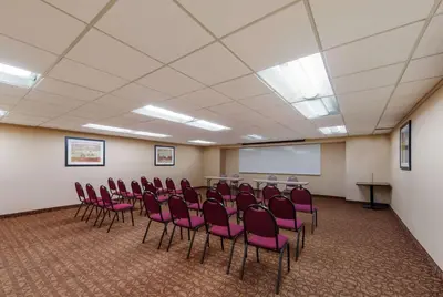 a conference room with pink chairs and a whiteboard at Best Western Executive Hotel New Haven-West Haven in West Haven