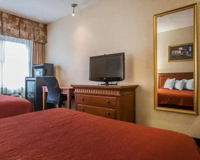 a hotel room with a bed and a television at Econo Lodge Glens Falls - Lake George in Glens Falls