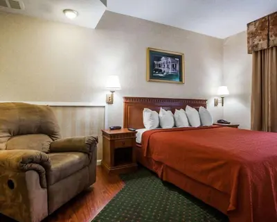 a hotel room with a bed and a couch at Econo Lodge Glens Falls - Lake George in Glens Falls