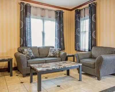 a living room with two couches and a coffee table at Econo Lodge Glens Falls - Lake George in Glens Falls