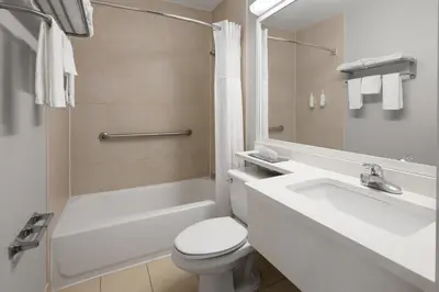 a white bathroom with a toilet and a sink at Microtel Inn by Wyndham - Albany Airport in Latham