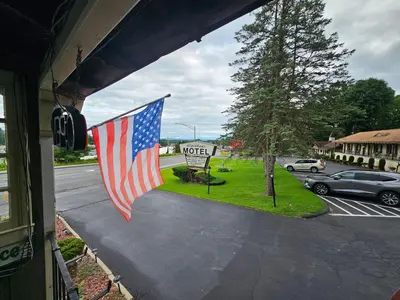 an american flag hanging from a window of a house at Alpenhaus Motel in Queensbury