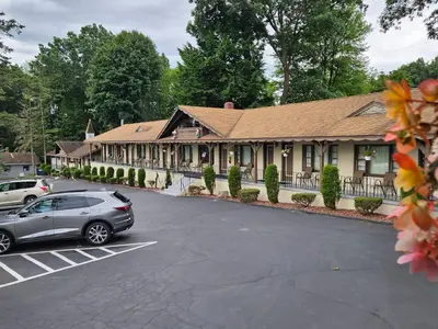 a car parked in a parking lot in front of a building at Alpenhaus Motel in Queensbury