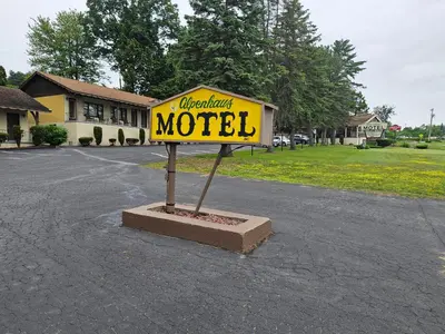 a yellow motel sign in the middle of a street at Alpenhaus Motel in Queensbury