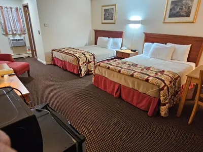 a hotel room with two beds and a couch at Alpenhaus Motel in Queensbury