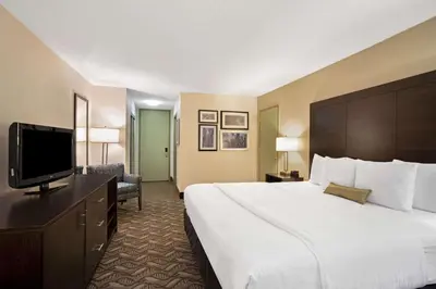 a hotel room with a large bed and a flat screen tv at La Quinta by Wyndham Springfield in Springfield
