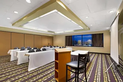 a conference room with tables and chairs and a large window at La Quinta by Wyndham Springfield in Springfield