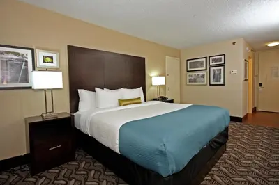 a hotel room with a large bed and two lamps at La Quinta by Wyndham Springfield in Springfield