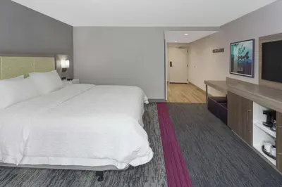 a hotel room with a bed and a flat screen tv at Hampton Inn & Suites Rocky Hill - Hartford South in Rocky Hill