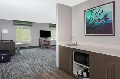 a hotel room with a sink and a living room at Hampton Inn & Suites Rocky Hill - Hartford South in Rocky Hill