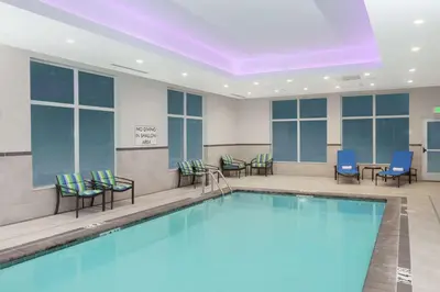 a pool in a hotel lobby with chairs and tables at Hampton Inn & Suites Rocky Hill - Hartford South in Rocky Hill