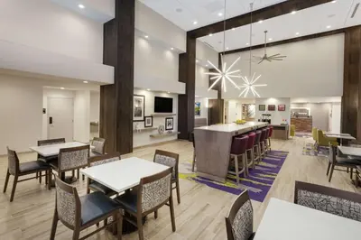 a restaurant with tables and chairs and a bar at Hampton Inn & Suites Rocky Hill - Hartford South in Rocky Hill