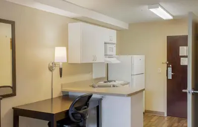 a kitchen with a table and a white refrigerator at Extended Stay America Suites - New York City - LaGuardia Airport in Queens
