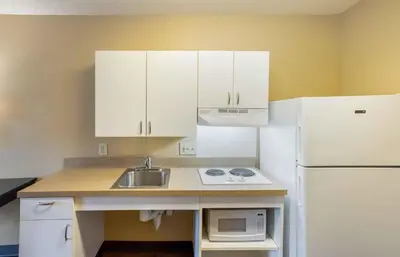 a small kitchen with a sink and a white refrigerator at Extended Stay America Suites - New York City - LaGuardia Airport in Queens