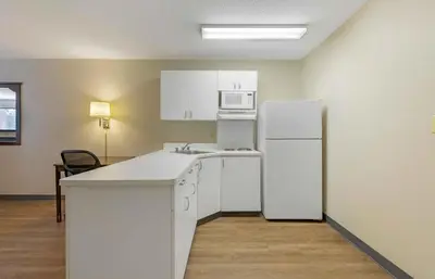a kitchen with white cabinets and a white refrigerator at Extended Stay America Suites - New York City - LaGuardia Airport in Queens