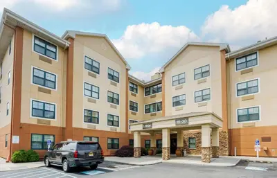 a car parked in front of a building at Extended Stay America Suites - New York City - LaGuardia Airport in Queens