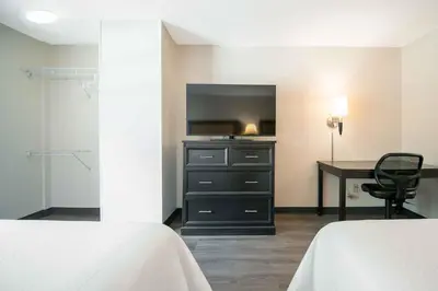 a bedroom with a desk and a dresser with a television at Extended Stay America Suites - White Plains - Elmsford in Elmsford
