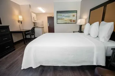 a hotel room with a large white bed and a desk at Extended Stay America Suites - White Plains - Elmsford in Elmsford