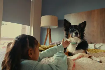 a little girl sitting on a bed with a dog at Extended Stay America Suites - White Plains - Elmsford in Elmsford