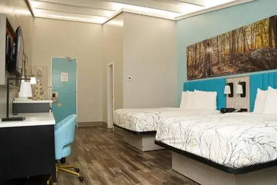 a hospital room with two beds and a desk at Days Inn by Wyndham Southington in Southington