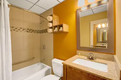 a bathroom with a sink and a toilet and a mirror at Days Inn by Wyndham Southington in Southington