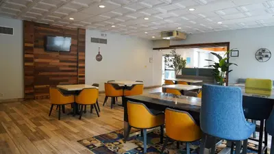 a dining room with tables and chairs and a television at Days Inn by Wyndham Southington in Southington
