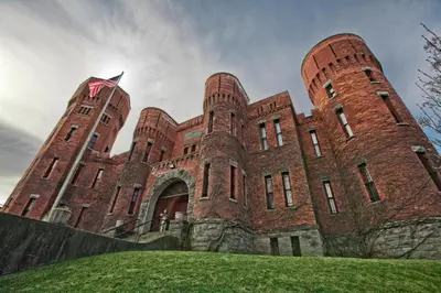 a large red brick building with a flag on it at Amsterdam Castle NY in Amsterdam