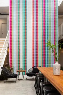 a wall with a colorful curtain in a room with chairs at Bluebird Spa City Motor Lodge in Saratoga Springs