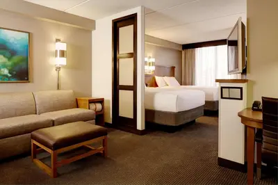 a hotel room with a bed and a couch at Hyatt Place Saratoga/Malta in Malta