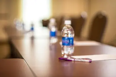 a bottle of water sitting on a table with a pen at Hyatt Place Saratoga/Malta in Malta