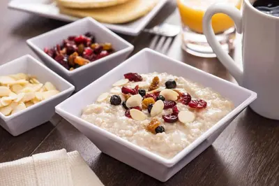 a bowl of oatmeal with fruit and nuts on a table at Hyatt Place Saratoga/Malta in Malta