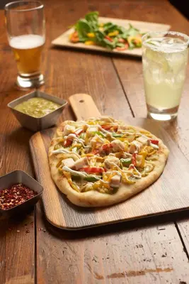 a pizza sitting on top of a wooden table at Hyatt Place Saratoga/Malta in Malta