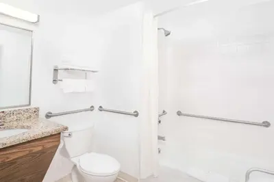 a white bathroom with a toilet and a shower at Super 8 by Wyndham Middletown in Middletown