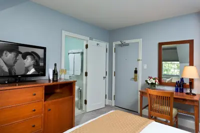 a bedroom with a television on a dresser with a desk at Gideon Putnam Resort & Spa in Saratoga Springs