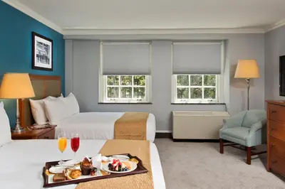 a hotel room with two beds and a tray of food at Gideon Putnam Resort & Spa in Saratoga Springs