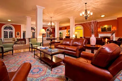 a living room with leather couches and chairs at Gideon Putnam Resort & Spa in Saratoga Springs