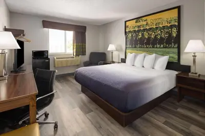 a hotel room with a large bed and a desk at Super 8 by Wyndham Latham - Albany Airport in Latham