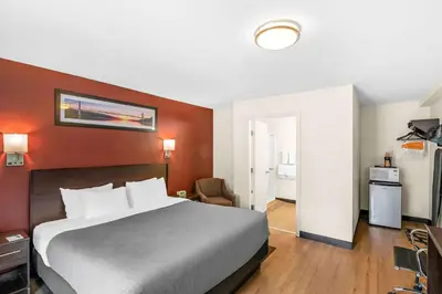 a hotel room with a large bed and red walls at Quality Inn Queensbury - Lake George Area in Queensbury