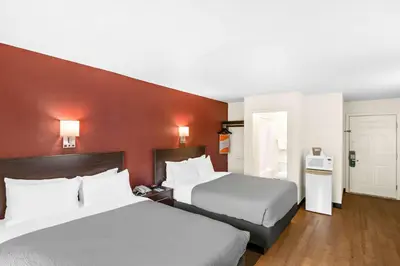 a hotel room with two beds and a red wall at Quality Inn Queensbury - Lake George Area in Queensbury