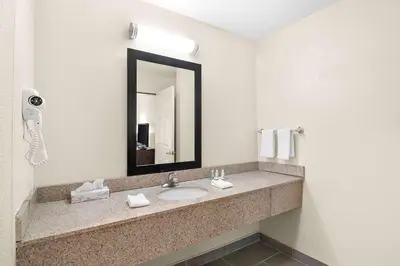 a bathroom with a sink and a mirror at Quality Inn Queensbury - Lake George Area in Queensbury
