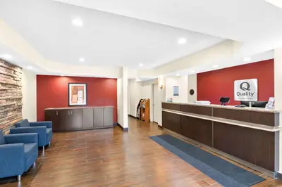 a lobby with a waiting area with blue chairs at Quality Inn Queensbury - Lake George Area in Queensbury