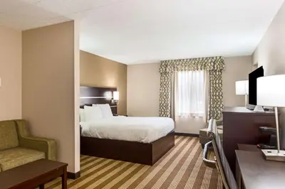a hotel room with a bed and a chair at Pocono Inn & Banquet - Stroudsburg in Delaware Water Gap
