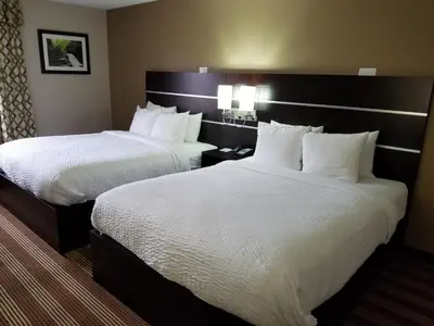 two beds in a hotel room with white pillows at Pocono Inn & Banquet - Stroudsburg in Delaware Water Gap