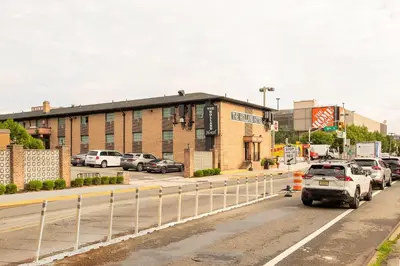a parking lot with cars parked in front of a building at Holland Hotel Free Parking Jersey City in Jersey City