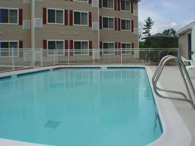 a large blue swimming pool in front of a building at Country Inn & Suites by Radisson, Queensbury - Lake George , NY in Lake George